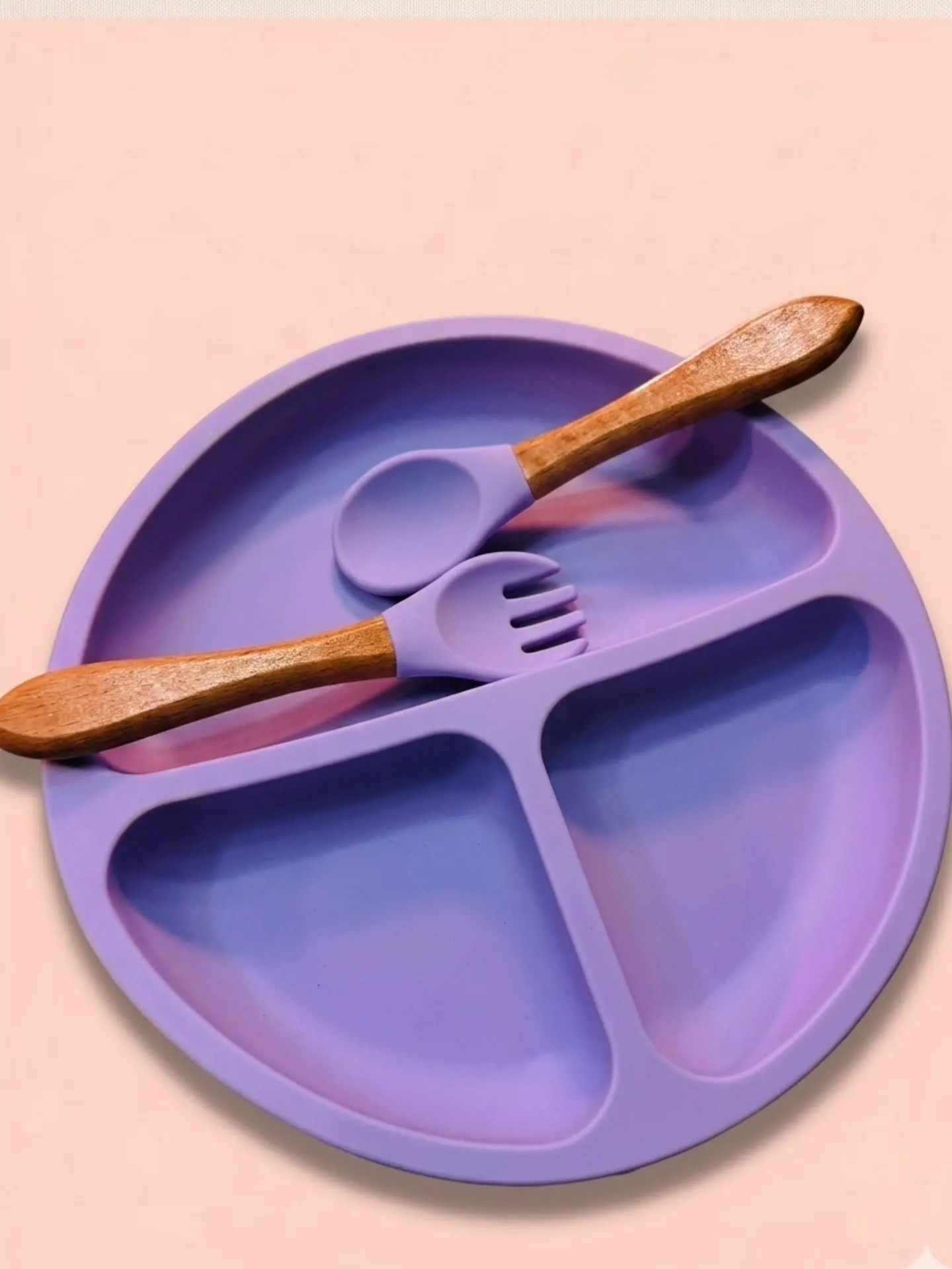 Pastel purple silicone divided baby suction plate with matching wooden handle spoon and fork.