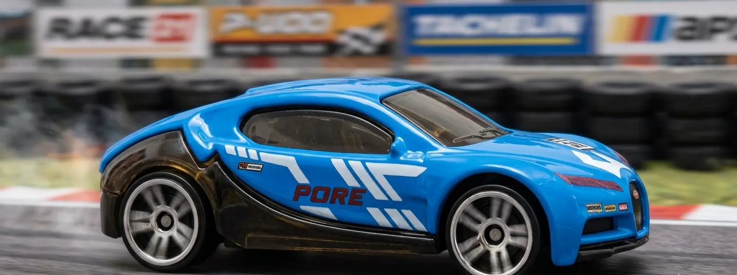 Packaged die-cast metal toy vehicle set showing a yellow helicopter, sports cars, and a motorcycle in red blister display boxes.