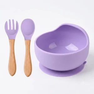 Pastel purple silicone baby suction bowl with matching wooden handle spoon and fork.